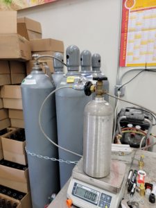 A 5# CO2 tank being filled by weight from a larger 100# CO2 tank at Quirky Homebrew Supply